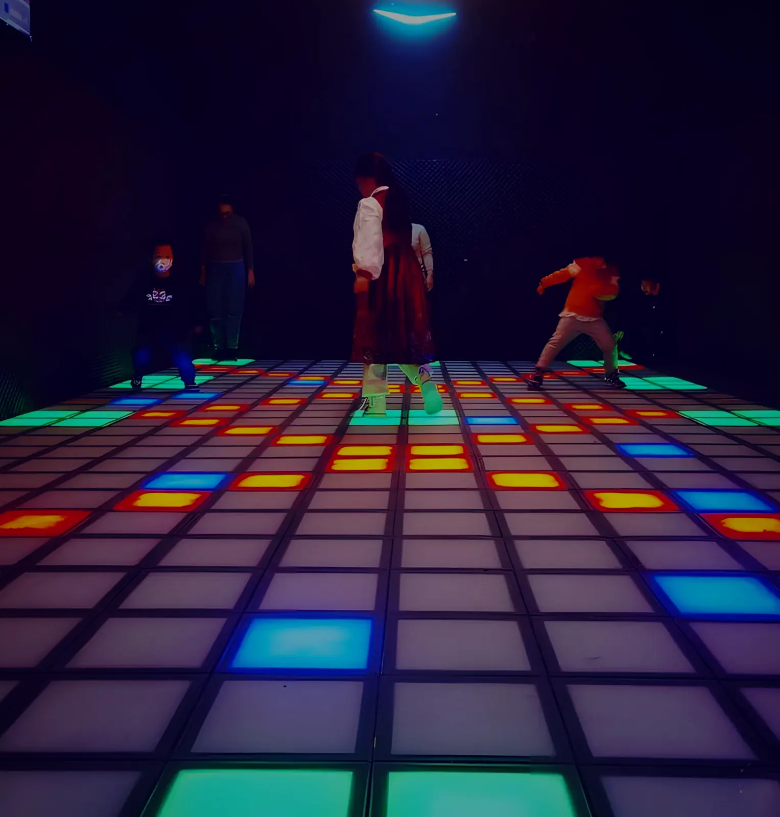 Children playing floor is lava on the LED tile floor at Lava Floor
